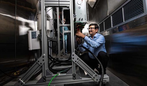 stationary Researcher working on the residential battery test bed in the Energy Systems Integration Facility.